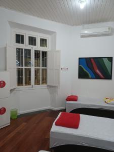 Una cama o camas en una habitación de Casarão Hostel & Quartos Privados