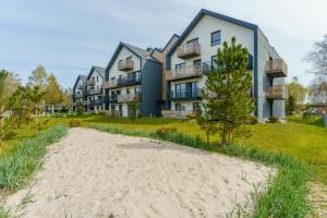 an apartment building with a beach in front of it at Apartament OAK TREE SurfingBird Dźwirzyno in Dźwirzyno