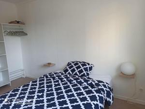 Schlafzimmer mit einem Bett mit einer blauen und weißen Bettdecke in der Unterkunft BEE COOL 75 m2 Le Verdon in Le Verdon-sur-Mer