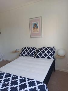 Schlafzimmer mit einem Bett mit blauen und weißen Kissen in der Unterkunft BEE COOL 75 m2 Le Verdon in Le Verdon-sur-Mer