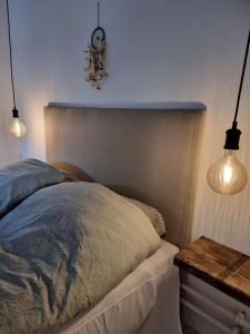 a bedroom with a bed with two lights on it at Calm and idyllic surroundings in Northen Jutland in Nibe