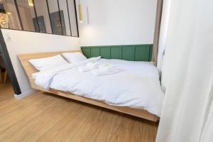 a bed with white sheets and two towels on it at Design & Chill #Altstadt #Beamer in Lutherstadt Wittenberg