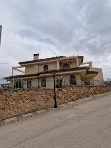 a large house on the side of a stone wall at Villa los Dulces-Piscina Privada in Letur