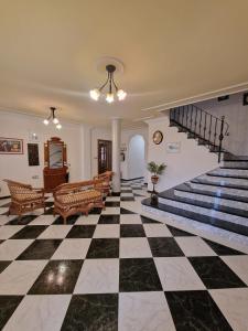 un vestíbulo con suelo a cuadros y escaleras en Villa los Dulces-Piscina Privada en Letur