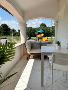 a patio with a couch and a table with a clown in the background at VOLMEness in Pula