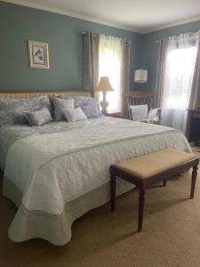 a bedroom with a large bed and a chair at Williston Village Inn in Burlington