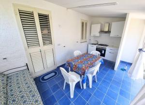 una stanza con tavolo, sedie e cucina di Omarvulcano1 - PROPPRO - isole eolie a Vulcano Altre 15 foto