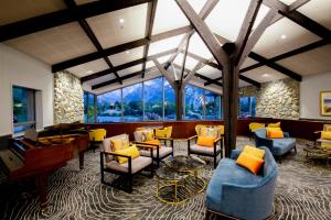 a lobby with chairs and tables and a large window at The Hermitage Hotel Mt Cook in Mount Cook Village