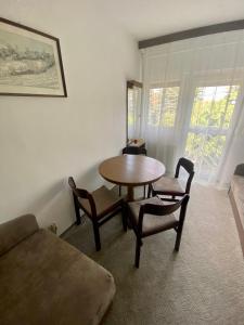 uma sala de estar com uma mesa e cadeiras e um sofá em Veronika Apartman em Balatongyörök