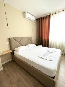sypialnia z dużym łóżkiem z białą pościelą w obiekcie Belix Seaview Apartments w Durrës