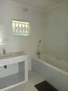 Kitwe的住宿－KMK APARTMENTS，浴室配有盥洗盆和浴缸。