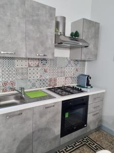 a kitchen with a stove and a sink at CASA Zia Sarina in Noto