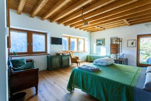 een slaapkamer met een groen bed en een bureau bij B&B Villa Grazia in Darfo