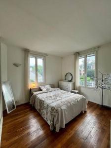 um quarto branco com uma cama e 2 janelas em Bel appartement /30 min de Paris em Louveciennes