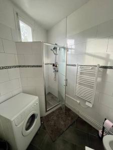łazienka z pralką i prysznicem w obiekcie Bel appartement /30 min de Paris w mieście Louveciennes