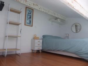 a bedroom with a bed and a white wall at Logement idéal au centre-ville in Cavalaire-sur-Mer