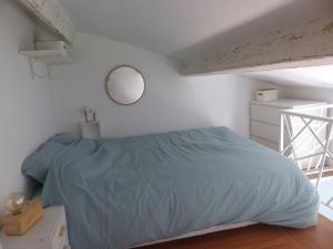 Un dormitorio con una cama y un espejo en la pared. en Logement idéal au centre-ville, en Cavalaire-sur-Mer 2 fotos más