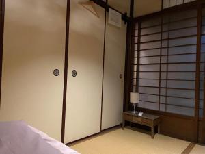 a bedroom with two closets and a bed and a table at Hotel Lantern Gion in Kyoto