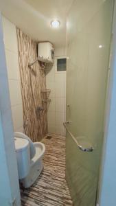 uma casa de banho com um WC e uma cabina de duche. em Apartment Centerpoint by RR Property em Kayuringin