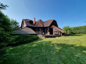 an old house in a field of green grass at Dom na Mazurach - Willa pod Jaworem in Olsztynek