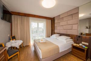 a hotel room with a large bed and a window at Villa Akacja in Łeba