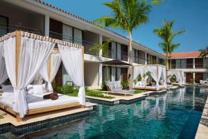 een zwembad van het hotel met witte bedden en een resort bij Dreams Flora Resort & Spa - All Inclusive in Punta Cana