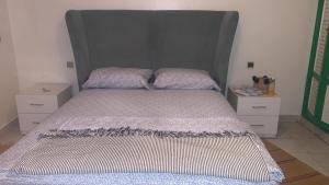 ein Bett mit einem großen Kopfteil in einem Schlafzimmer in der Unterkunft APPARTEMENT PERLE RARE AU CENTRE DE MARRAKECH in Marrakesch