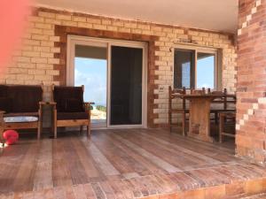 een patio met schuifdeuren en een tafel en stoelen bij Ageba Beach Marsa Matrouh Chalet 103 صف اول بحر in Zâwyet Umm el Rakham