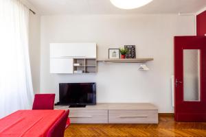 uma sala de estar com uma televisão de ecrã plano na parede em Turin In Wine: appartamento incantevole a Torino. em Turim