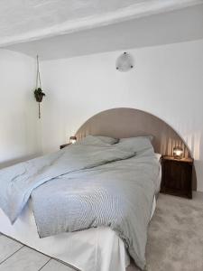 a white bedroom with a large bed with a large headboard at Calm and idyllic surroundings in Northen Jutland in Nibe