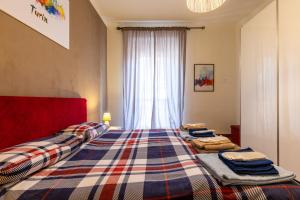 a bedroom with two beds with a plaid blanket at Turin In Wine: appartamento incantevole a Torino. in Turin