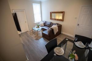 a living room with a couch and a table at Blessed Burnville Home with Parking in Sunderland
