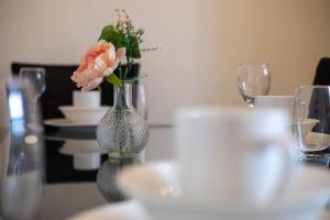 a vase with flowers in it sitting on a table at Blessed Burnville Home with Parking in Sunderland