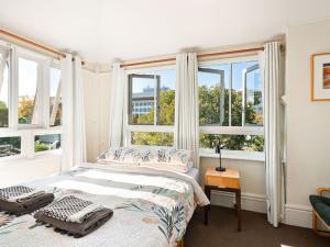a bedroom with a bed and two windows at Lord Wolseley Hotel in Sydney