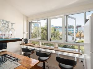 uma cozinha com janelas, uma mesa e cadeiras em Lord Wolseley Hotel em Sidney