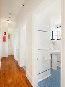 uma casa de banho branca com um lavatório e um espelho em Lord Wolseley Hotel em Sydney