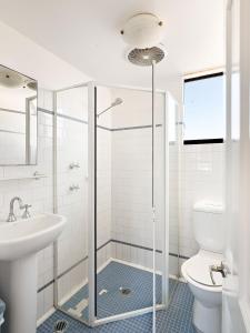 uma casa de banho com um chuveiro, um WC e um lavatório. em Lord Wolseley Hotel em Sydney