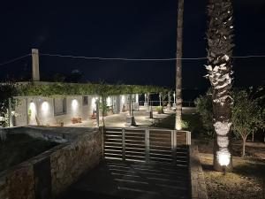 a house with a gate and a palm tree at night at Seaside Private Beach Paradise in Kos
