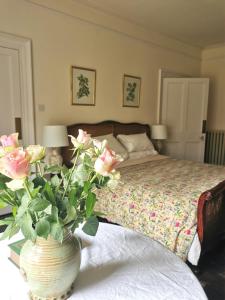 a bedroom with a bed and a vase with flowers on a table at ASHLEY COURT in Tiverton