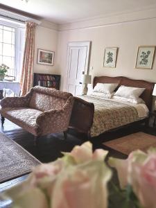 a bedroom with a bed and a couch and a chair at ASHLEY COURT in Tiverton