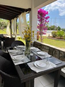 a table with plates and a vase of flowers on it at Hacienda ZK in Nea Potidaea