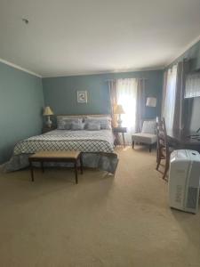 1 dormitorio con 1 cama, mesa y sillas en Williston Village Inn en Burlington