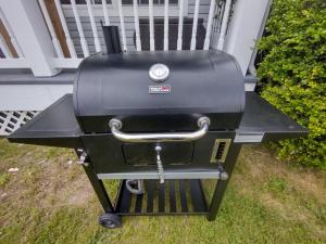 a grill sitting on the grass in front of a house at AMAZING!!!! Luxury 5BR, Steps to beach and Fun! Fully Renovated Beach house! in Atlantic City