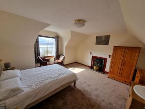a bedroom with a bed and a fireplace at Altdarroch Farm House in Kinlocheil