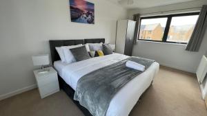 a bedroom with a large bed and a window at Large, spacious and cosy 5 bedroom house at Broughton, Sleeps up to 9 guests. Located just off junction 14 of the M1, it is perfectly located and a short drive to Milton Keynes City Centre, Train Station, Gulliver's Theme Park, Intu Shopping Centre. in Broughton