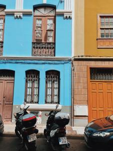 una motocicleta estacionada frente a un edificio azul en La casita de La laguna, en La Laguna