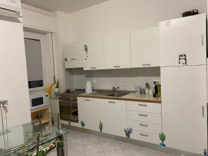 uma cozinha com armários brancos e um lavatório em Polly em Rapallo