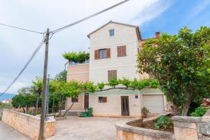 ein großes weißes Haus mit Bäumen davor in der Unterkunft Bepa in Supetar