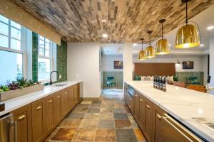a large kitchen with wooden cabinets and a tile floor at Burlingame 1BR w gym wd rooftop nr Caltrain SFO-1056 in Burlingame