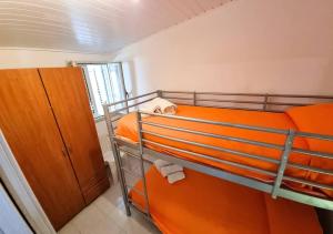 武爾卡諾島的住宿－Elivulcano4 - PROPPRO - isole eolie，一间卧室配有两张双层床,提供橙色床单